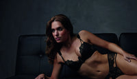 Exquisite black lace Lauren Cutout Thong Panty and matching bra on a model.